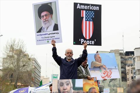 A man holds a portrait of the Iranian Supreme Leader and an anti-US sign as Iranians attend a rally marking Al-Quds Day (Jerusalem), a commemorative day held annually on the last Friday of the Muslim fasting month of Ramadan, in Tehran, on March 28, 2025. (AFP photo)